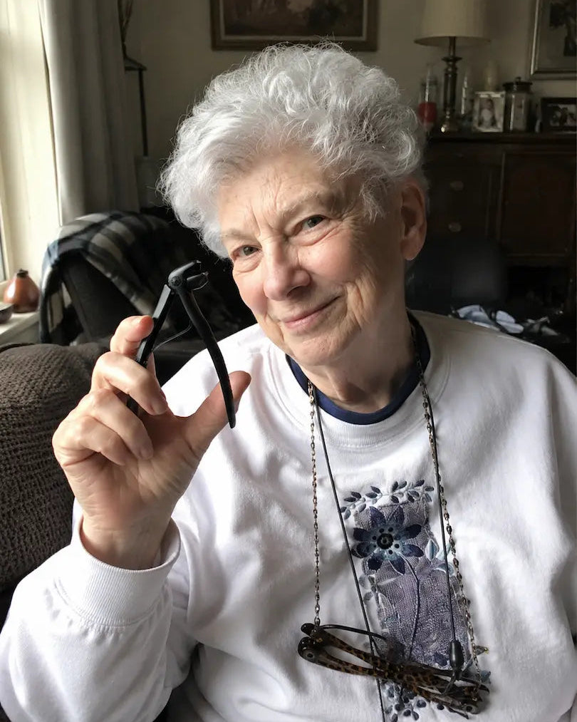 Senior woman holding the Relievana Premium Nail Clipper Set before trimming her toenails.